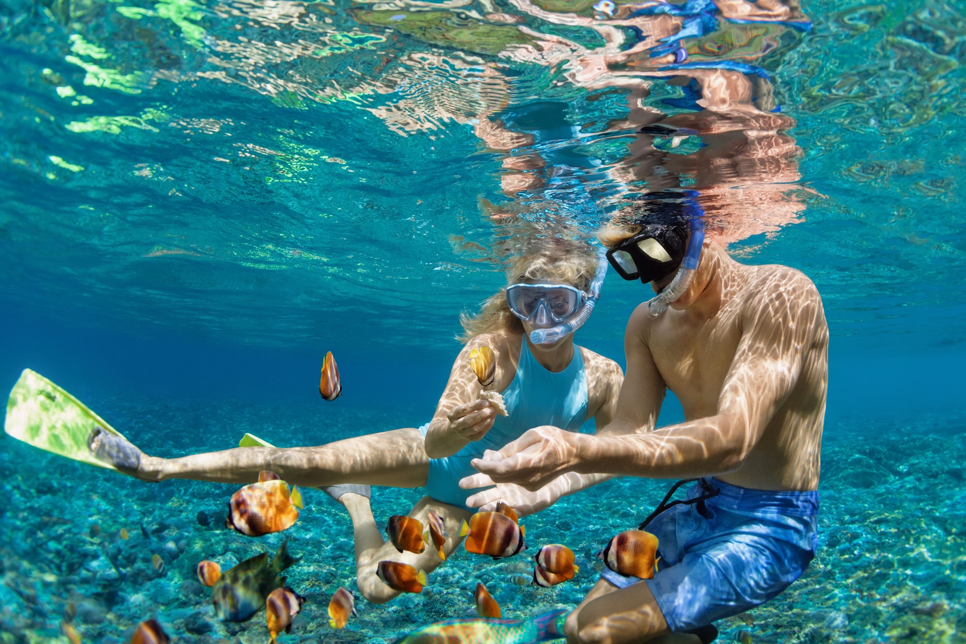 Young couple in snorkeling mask dive underwater in tropical sea