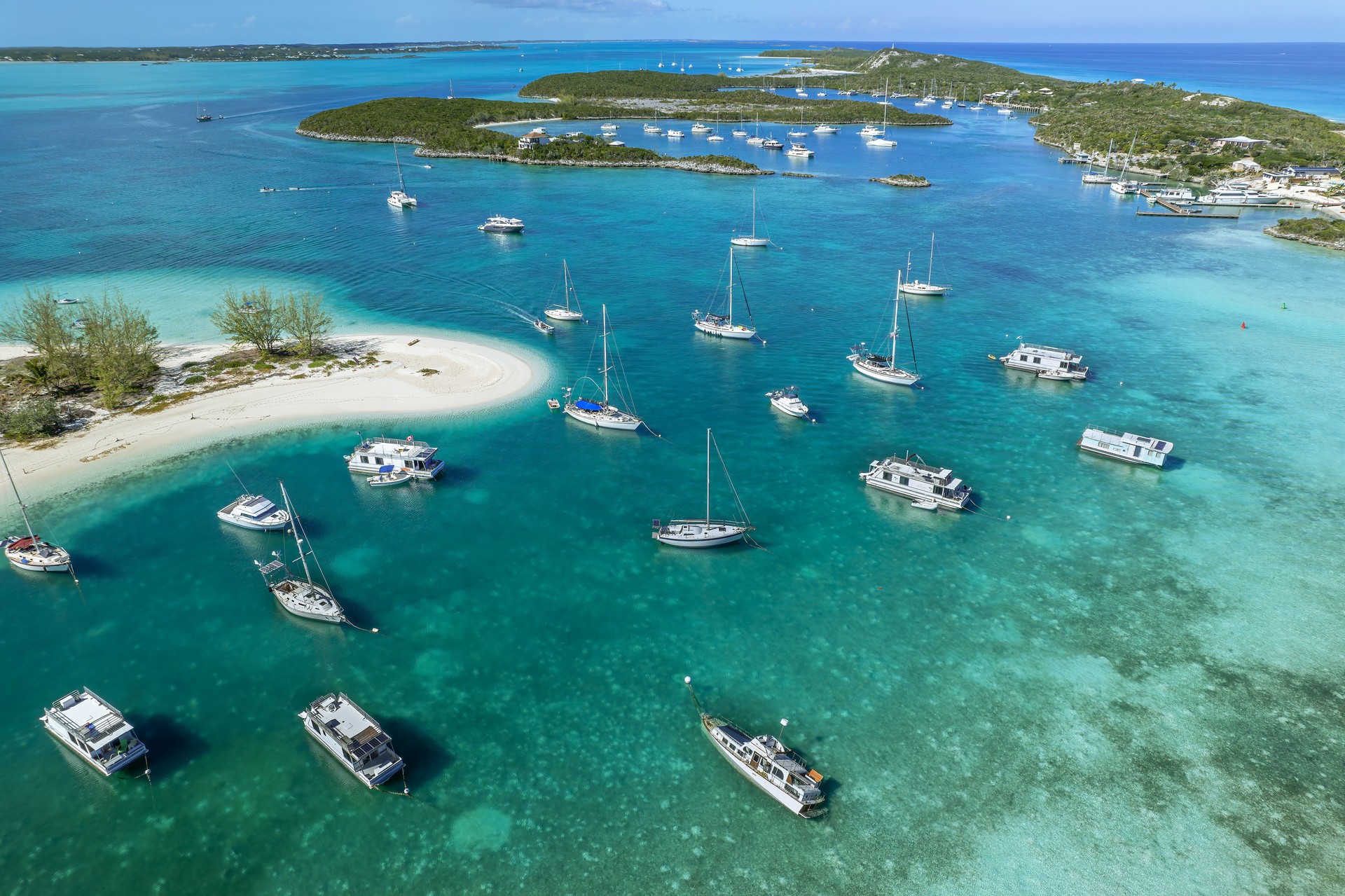 Drone aerial view of anchored sailing yacht in emerald Caribbean Sea, Stocking Island, Great Exuma, Bahamas.